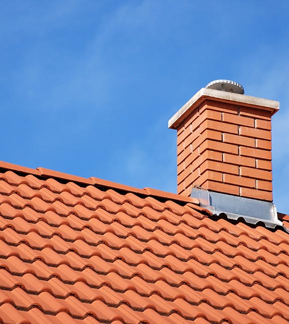 smoke stack on the tiled roof of a family house