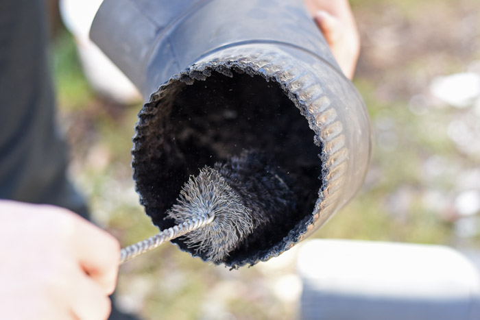 close-up of man cleaning chimney pipe