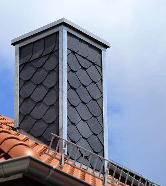 New tiled roof with chimney with slate cladding