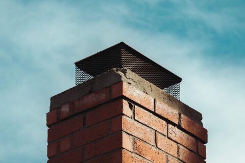 A brick chimney with a chimney cap